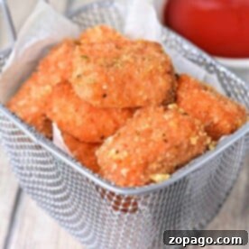 Golden succulent salmon bites, while a bowl of ketchup waits eagerly in the background.