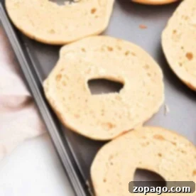 Sliced bagels placed on a baking sheet, showing how to toast a bagel in the oven for perfectly crisp results.