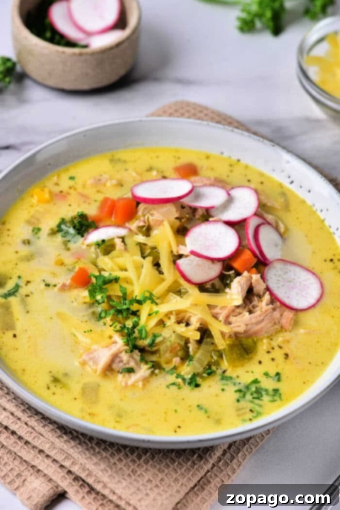 Velvety Poblano Chicken Soup 2 A large bowl of creamy chicken poblano soup, garnished with fresh herbs and a swirl of cream.