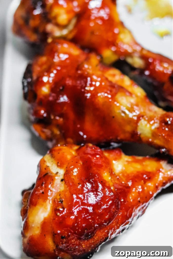 Crispy Smoked Chicken Drumsticks 5 Smoked Chicken Drumsticks on a Traeger grill, perfectly cooked with a rich, dark crust.