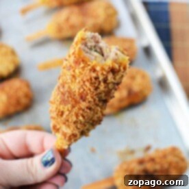 A hand holds a breaded, fried mock chicken with a bite taken, revealing the savory interior reminiscent of mock chicken legs.