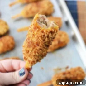 A hand holds a breaded, fried mock chicken with a bite taken, revealing the savory interior reminiscent of mock chicken legs.