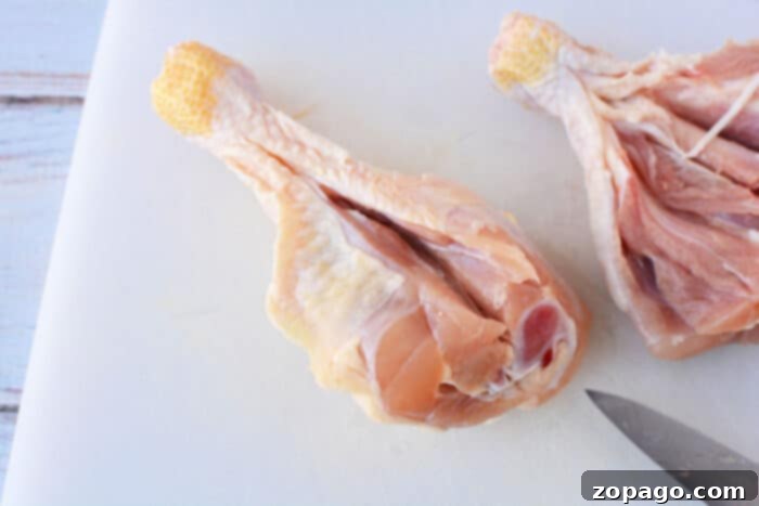 Crispy Oven Butterfly Chicken 3 Expertly butterflied chicken legs on a cutting board, ready for seasoning.