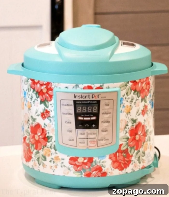 Instant Pot Versus Crock Pot Express The Multicooker Showdown 3 A brightly colored multi-cooker with a floral pattern graces the white kitchen counter, perfect for whipping up instant pot Thanksgiving recipes. It features a digital display and various labeled buttons for diverse cooking options.