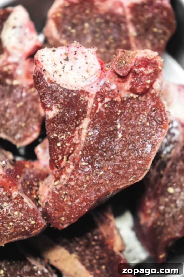 Perfectly Seared Lamb Loin Chops 3 Close-up of raw, seasoned lamb loin chops ready for cooking.
