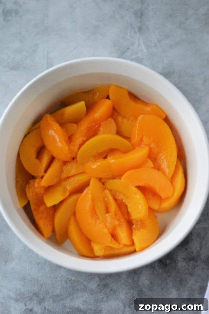 Easy Cake Mix Peach Cobbler 4 Easy Peach Cobbler Recipe served with a scoop of vanilla ice cream.