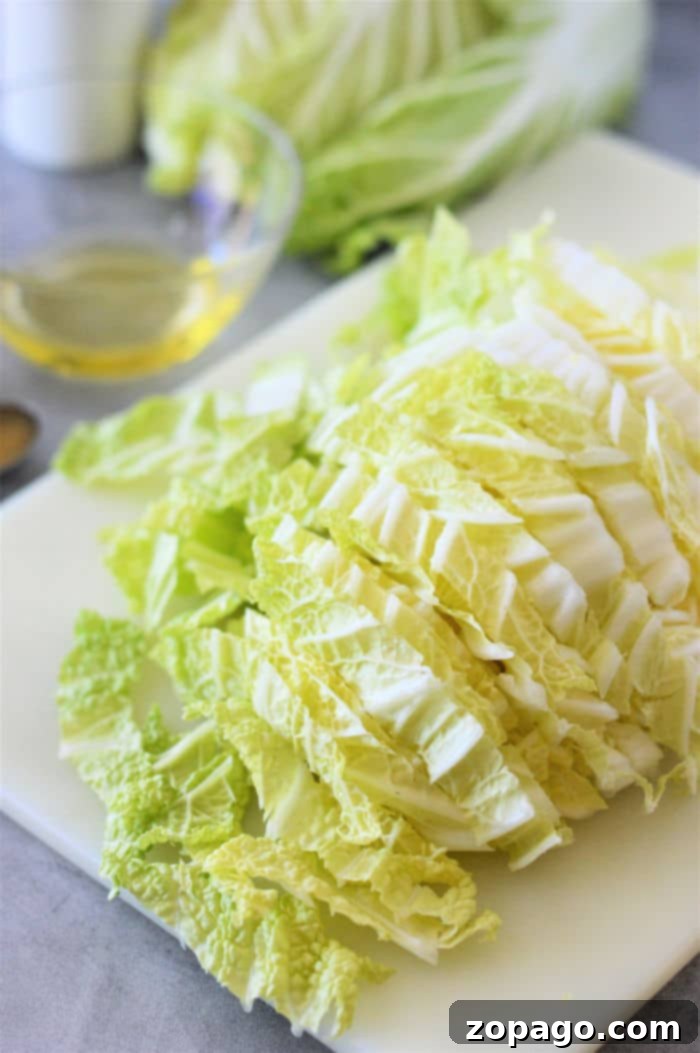 Easy Napa Cabbage Recipes 4 How to Cook Napa Cabbage - A skillet filled with partially cooked Napa cabbage, garlic, and butter, showing the process.