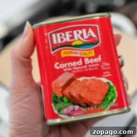 Hand holding a can of Iberia Corned Beef in natural juices, product of Brazil, with halal certification—perfect for your next canned corned beef recipe.