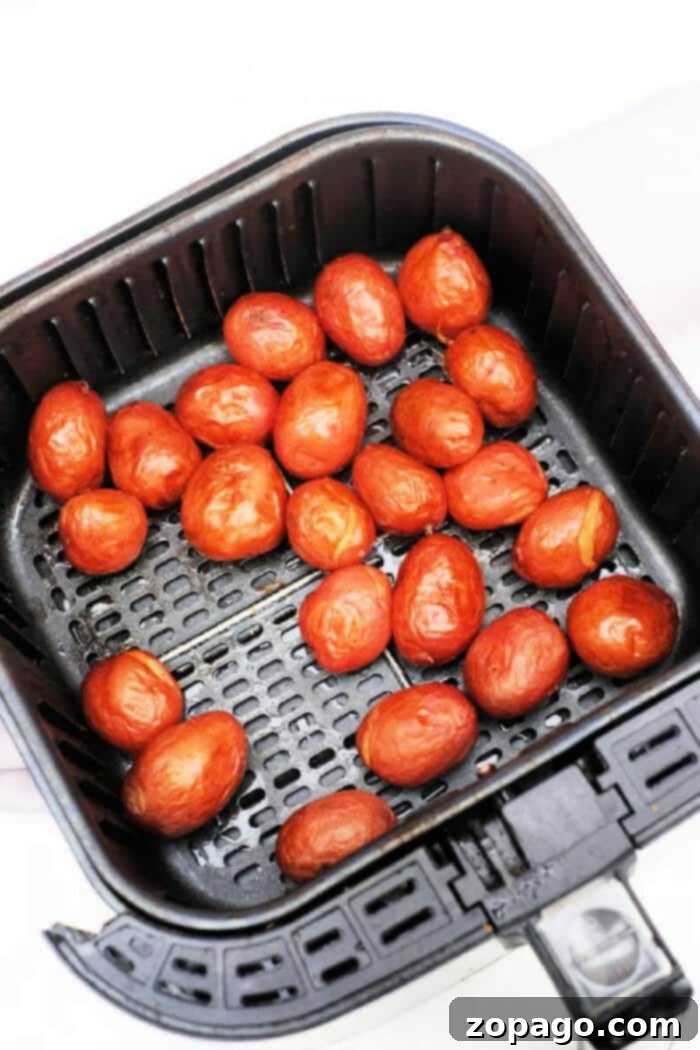 Crispy Air Fryer Baby Potatoes 2 Freshly cooked baby red potatoes, nestled in a black air fryer basket, offer a delightful twist on your favorite baby potatoes recipe, showcasing their crispy exterior.