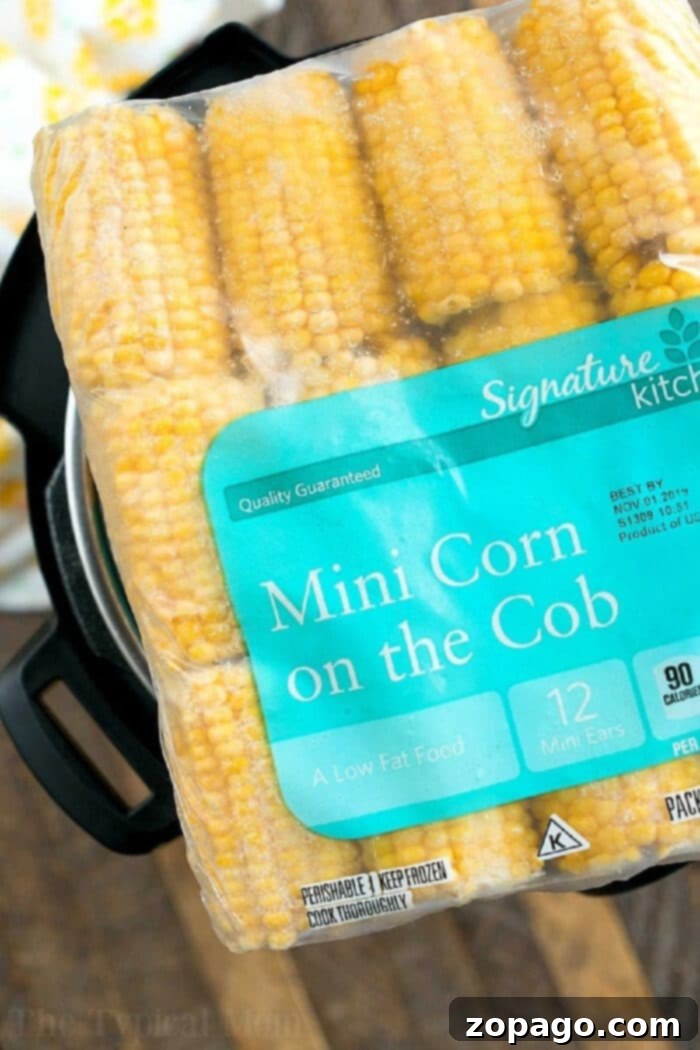 Perfectly Cooked Frozen Corn on the Cob Every Time 4 Three perfectly cooked frozen corn cobs on a cutting board, ready to be seasoned