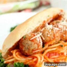 Leftover Spaghetti Sandwich Perfection 7 Indulge in a Spaghetti Sandwich featuring savory meatballs and grated cheese, crowned with a sprinkle of fresh parsley.