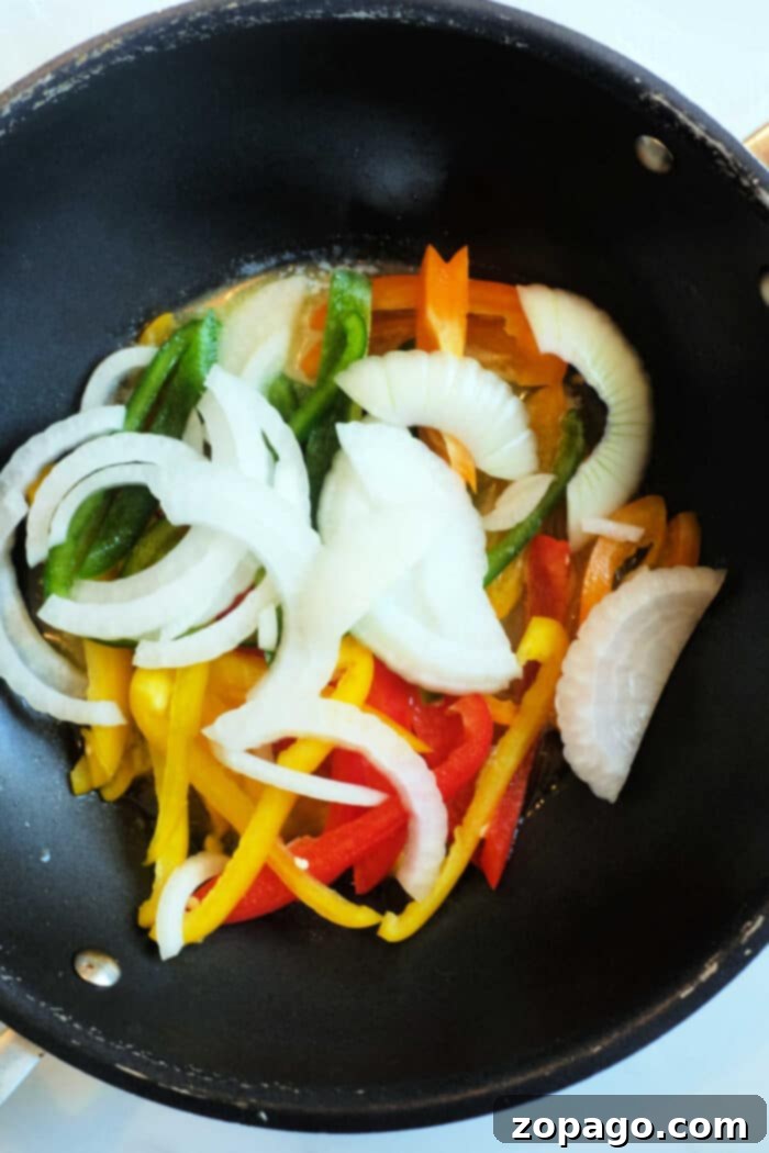 Island Braised Cabbage 5 Jamaican Fried Cabbage in a large skillet, featuring golden-brown cabbage with colorful vegetables