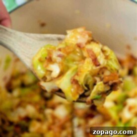 A wooden spoon lifts a delicious mixture, embodying the perfect cabbage and bacon recipe, right from the pot.
