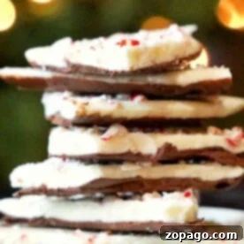 Easy Microwave Peppermint Bark 4 A stack of chocolate peppermint bark, freshly made in the microwave, sits majestically with twinkling lights glowing softly in the background.