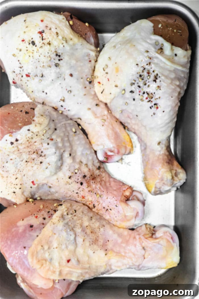 Frozen Chicken Shelf Life 5 Chicken drumsticks, seasoned with salt and pepper, rest enticingly in a metal baking tray.