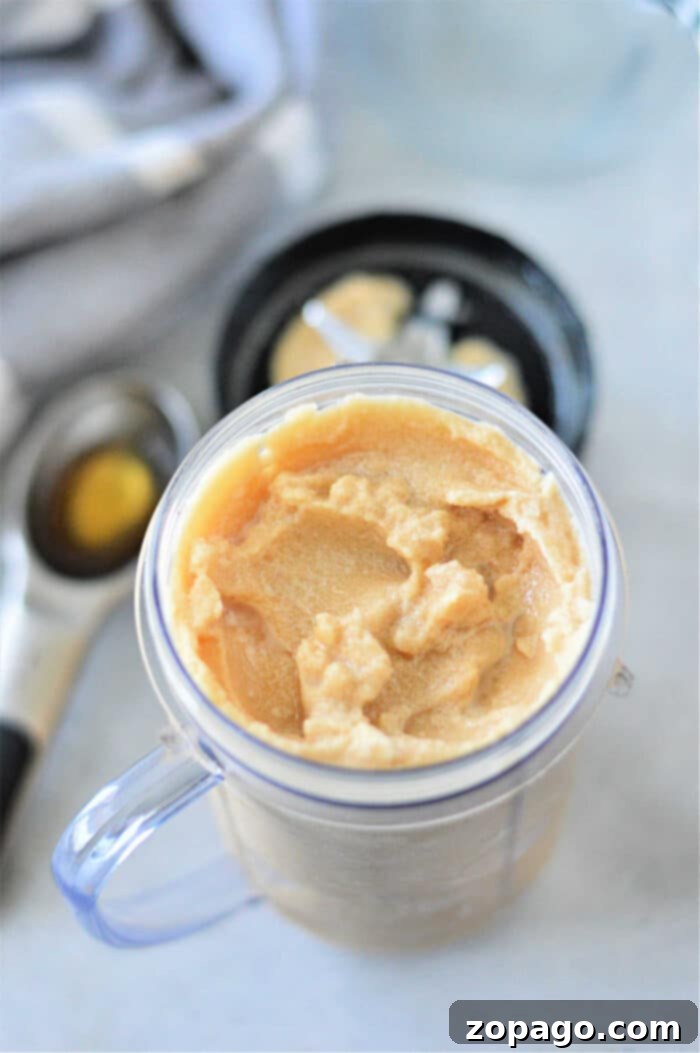 Blended Iced Coffee 12 Frozen coffee in a clear container with a black lid, accompanied by an ice cream scoop nearby.