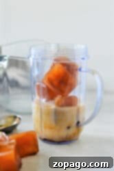 Blended Iced Coffee 5 Ice cubes, milk, and a hint of frozen coffee sit in a blender cup on the kitchen counter.