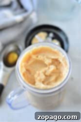 Coffee Frappe 6 Frozen coffee in a clear container with a black lid, accompanied by an ice cream scoop nearby.