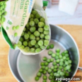 Elevate Your Frozen Peas 7 A bag of frozen peas cascades into a saucepan, landing softly on the wooden surface.