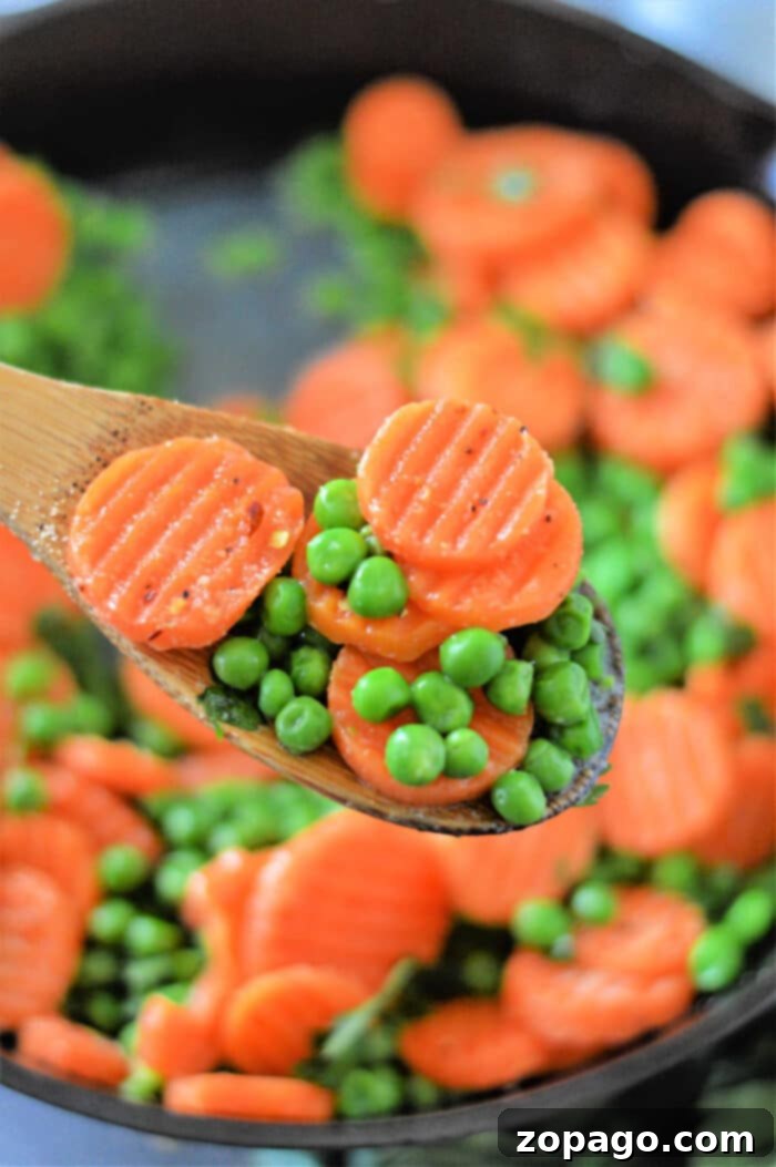 Mastering Frozen Peas and Carrots 2 Sizzling frozen peas and carrots cooking in a skillet on the stove, a perfect method for a quick, flavorful side dish.