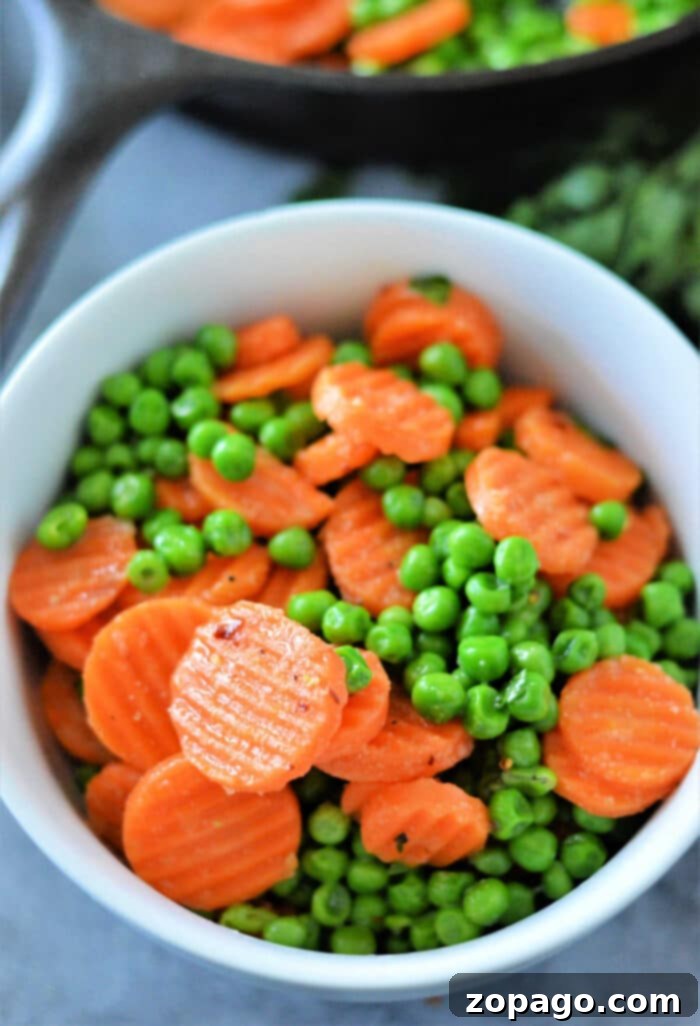 Mastering Frozen Peas and Carrots 7 A colorful medley of perfectly cooked frozen peas and carrots in a serving bowl, beautifully seasoned and ready to be enjoyed.