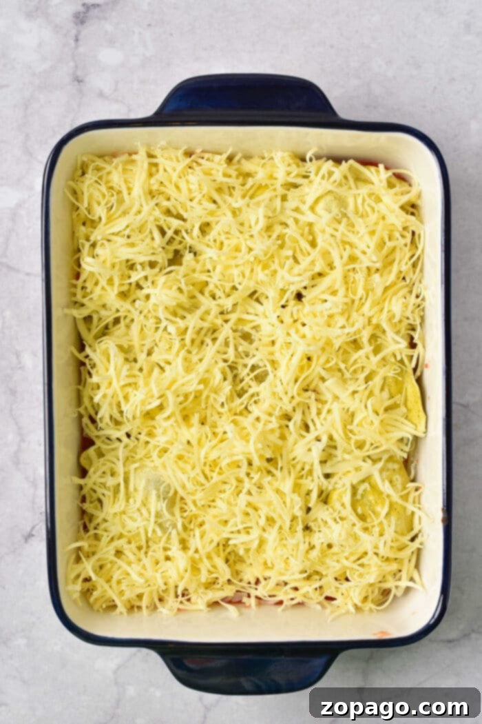 No-Boil Ravioli Lasagna 5 A serving of baked ravioli casserole on a plate, showing the cheesy layers.