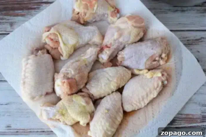 Perfect Oven Wings Cook Time Guide 3 Several raw chicken wings placed on a paper towel, to dry.