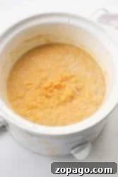 Close-up of a slow cooker with creamy yellow oatmeal inside, perfect for those mornings when you need a warm and cozy start. This versatile appliance can also craft delectable lentils, bringing comforting flavors to your table.