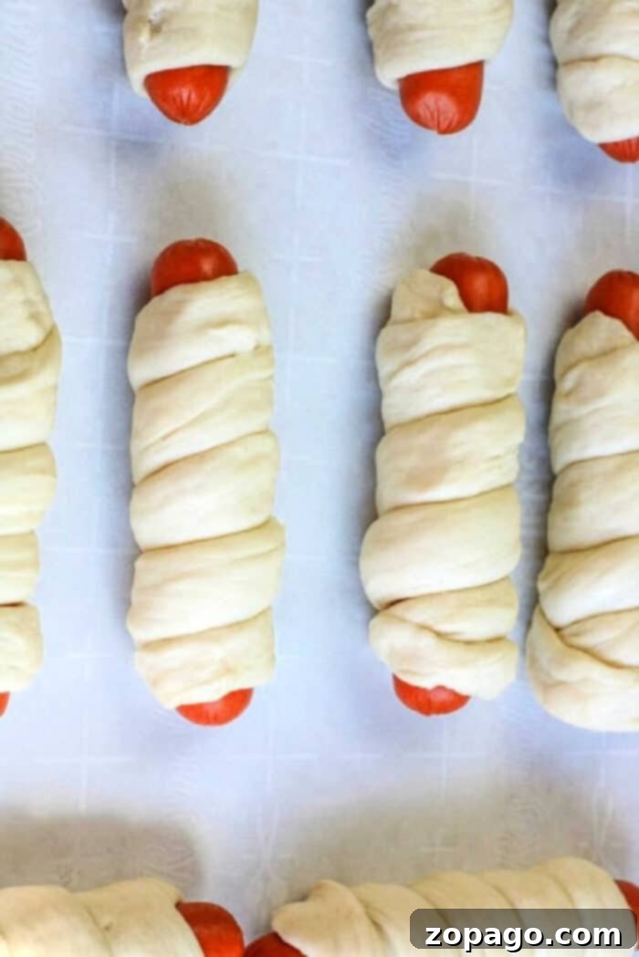 Pigs in a Puff 3 Pigs in a blanket with a golden-brown crust, fresh from the oven, showing perfect crispness and ready to be dipped.