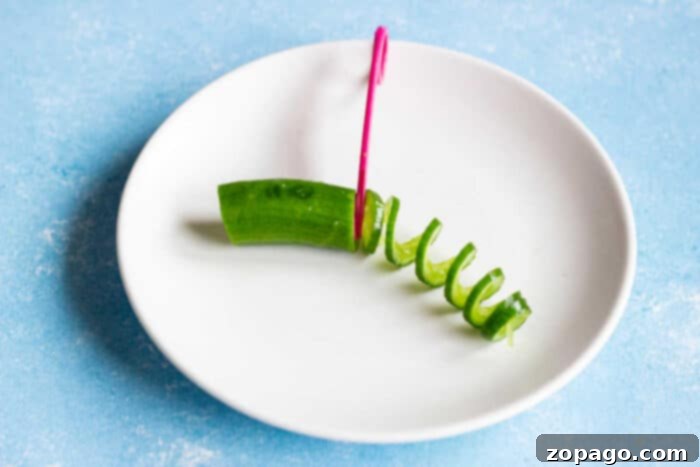 Oi Muchim 3 A bowl of Korean Cucumber Salad with a spoon, highlighting the spiralized cucumbers and fresh ingredients.