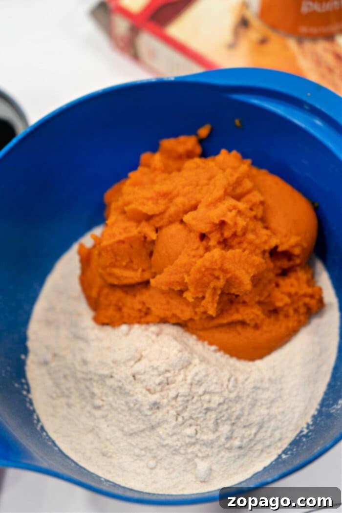 Spice Cake Mix Pumpkin Bread 4 The blue bowl holds a delightful blend of cake mix and pumpkin puree, the perfect base for crafting a batch of pumpkin bread with spice cake mix.