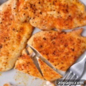 Grilled chicken breast slices are served on a plate with forks, seasoned perfectly with spices. Curious about cooking? If youre wondering how long to cook thin chicken breast in the oven, precise timing ensures juicy and flavorful results.