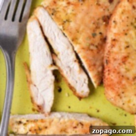 Easy Air Fryer Thin Chicken Breast 7 Thinly sliced chicken breast, perfectly tender, elegantly rests on a green plate beside a fork. Cooked to perfection in the air fryer at 375 degrees, each bite promises a delicious experience.