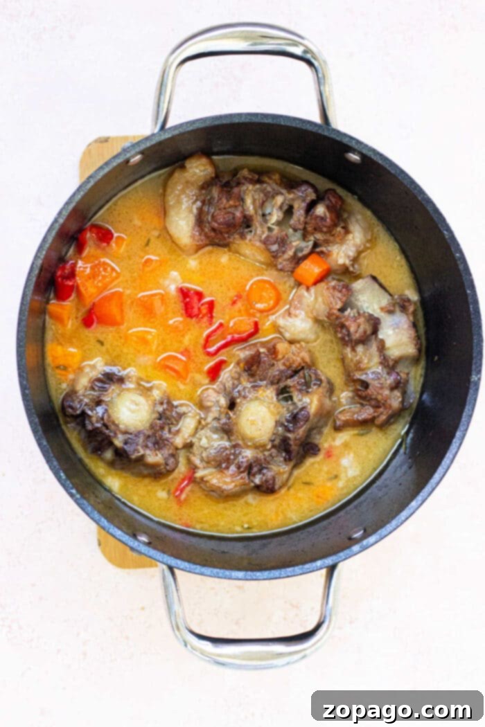 Braised Oxtail in a Dutch Oven 5 Oxtail with Potatoes - A bowl of tender oxtail stew served with chunks of potato.