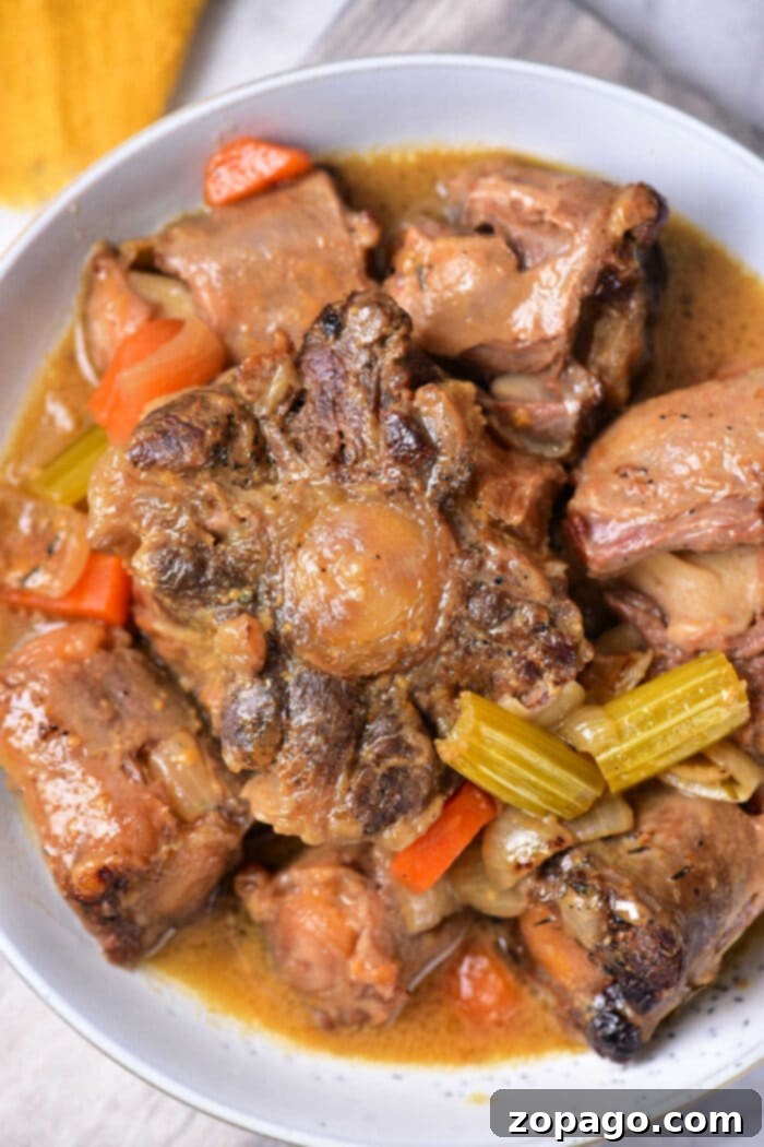 Slow-Cooked Oxtail Perfection 2 Braised Oxtail Recipe: Tender beef in a rich gravy sauce with carrots and onions, perfect for a hearty meal.