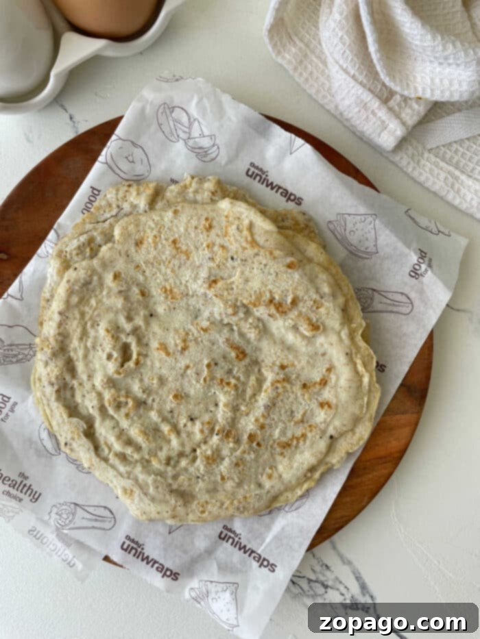Protein Egg Wraps 5 A stack of golden brown tortillas made from egg whites, served on a plate with garnishes, ready to be enjoyed.