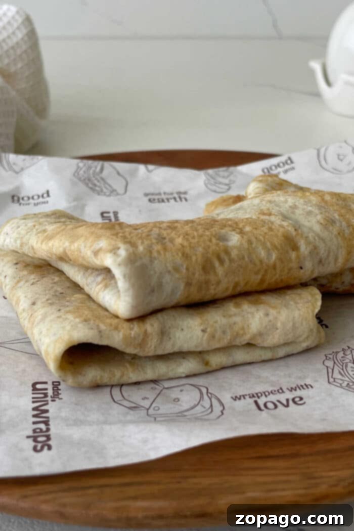 Protein Egg Wraps 7 A perfectly cooked egg white tortilla, resting on a white plate, highlighting its smooth, delicate surface.