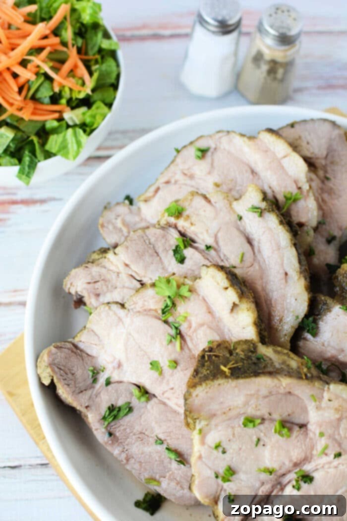 Tender Instant Pot Pork 5 Sliced roast pork, tenderly prepared in an Instant Pot and garnished with fresh herbs, elegantly arranged on a plate with a crisp salad and seasonings.