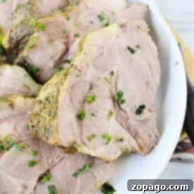 Slices of seasoned tender pork roast, garnished with fresh parsley on a white plate, showcasing efficient pressure cooking results.