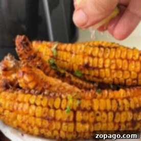 Corn on the cob ribs, with a hint of spice and a squeeze of lime, lays temptingly on parchment paper, reminiscent of a delightful corn ribs recipe.