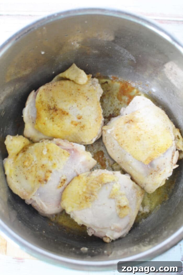 Easy Instant Pot BBQ Chicken Thighs 4 Close-up of pressure cooker BBQ chicken thighs, glistening with sauce, ready to be finished.