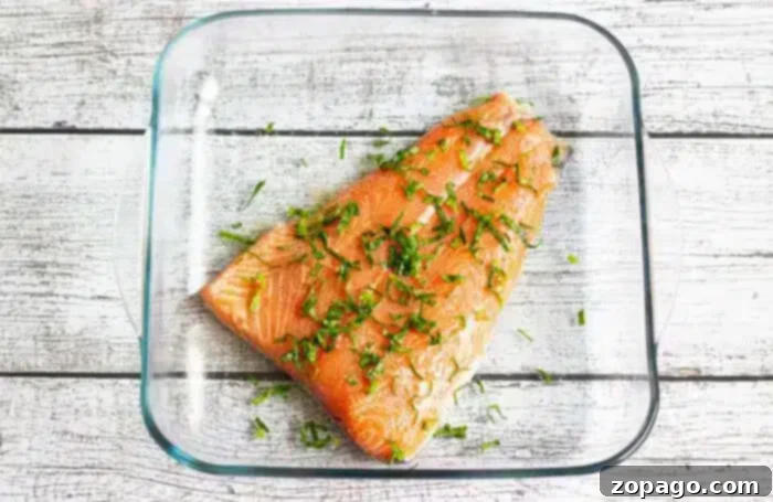 Perfect Baked Salmon Timing at 350 Degrees 4 A raw salmon fillet, seasoned with chopped herbs, ready for baking.