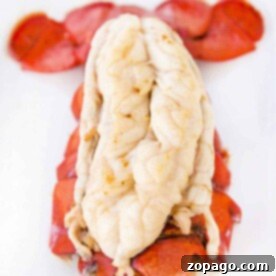 Close-up of an Instant Pot lobster tail, with the shell partially removed and the tender white meat exposed against a plain background.