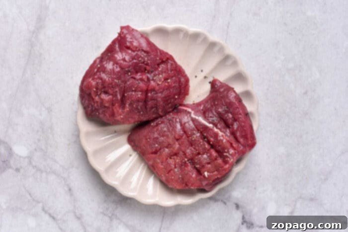Tenderized Venison Steak 3 Uncooked venison steak, perfectly cut and prepared for tenderizing, showcasing its rich red color and lean texture.