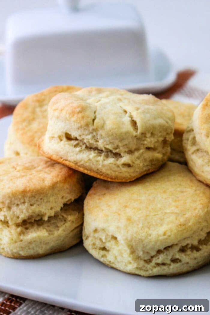 Deliciously golden-brown Crisco Biscuits stacked on a plate, ready to be served.