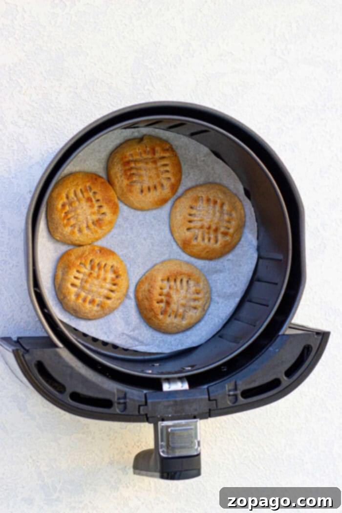 Golden Air Fried Peanut Butter Delights 5 A batch of Ninja Foodi peanut butter cookies cooling in the air fryer basket, with perfect criss-cross marks.