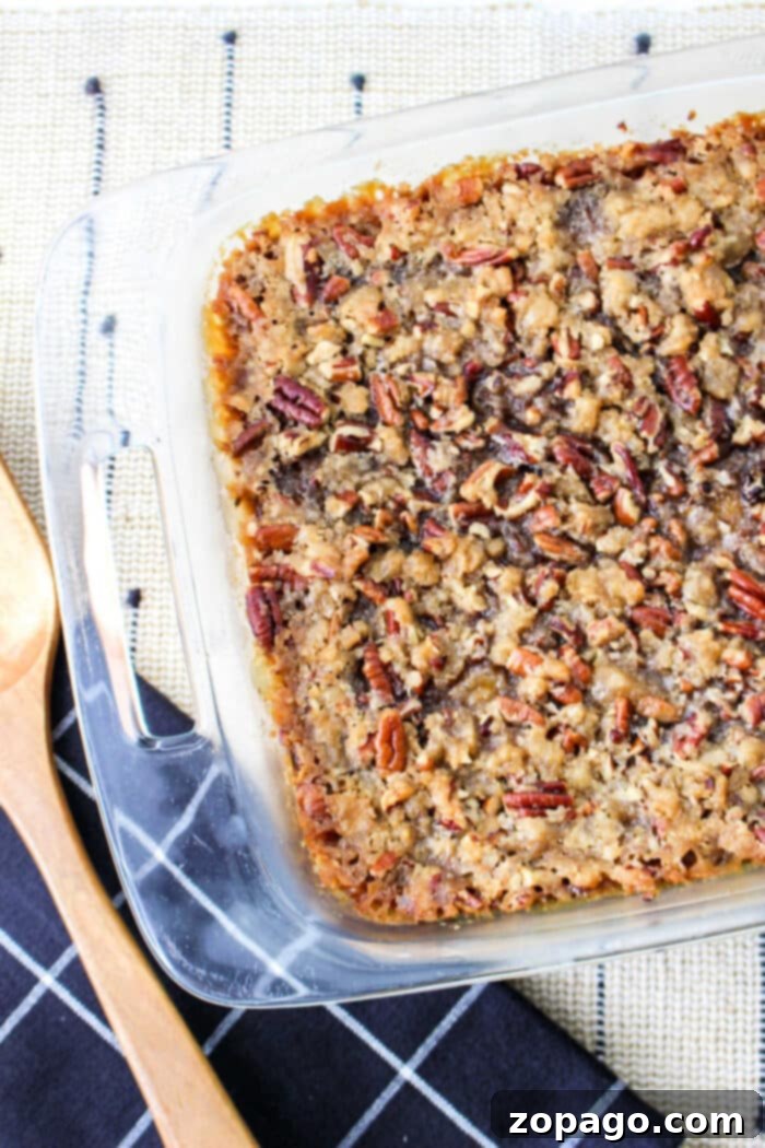 No-Fuss Sweet Potato Casserole with Canned Yams 6 A glass baking dish with a freshly baked sweet potato casserole with canned yams, accompanied by rustic wooden cooking utensils.