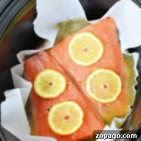 Effortless Slow Cooked Salmon 8 Crockpot salmon fillets with lemon slices rest delicately in a slow cooker lined with parchment paper.