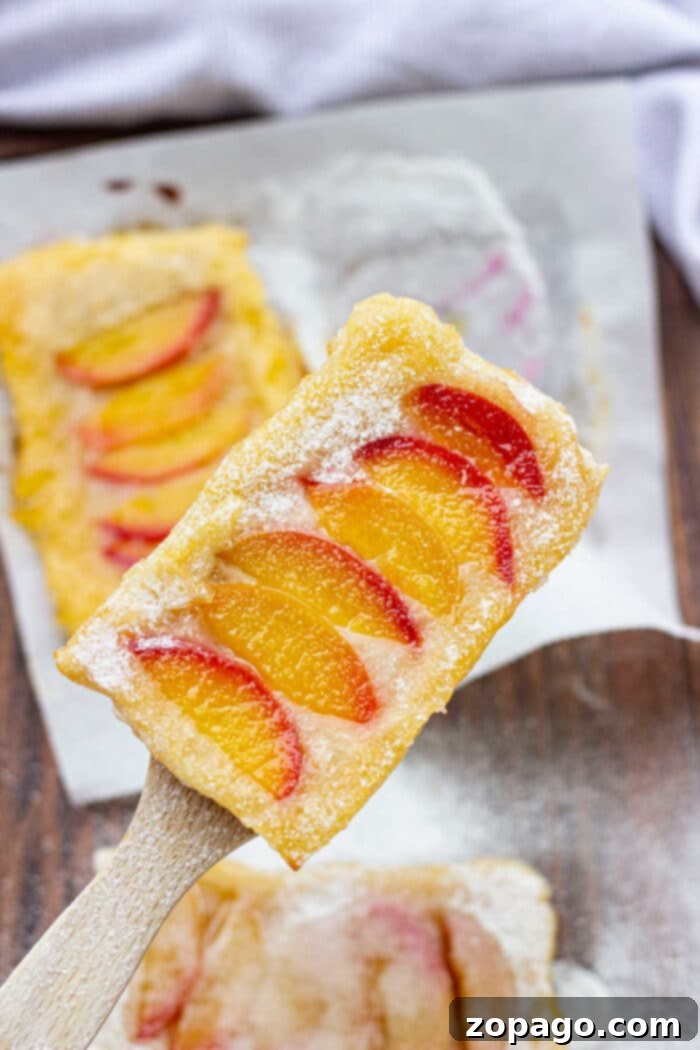 Assortment of puff pastry fruit tarts with various toppings.