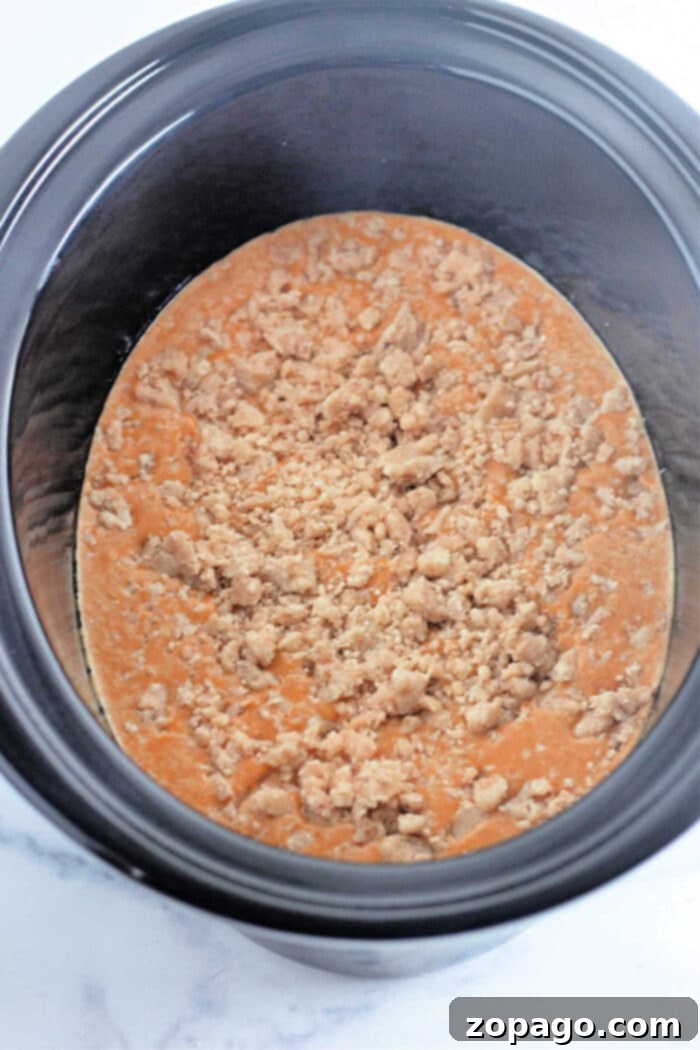 A warm and inviting pumpkin crockpot dump cake, beautifully golden brown and topped with nuts, ready to be enjoyed.
